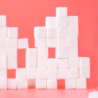 stacked sugar cubes on pink background